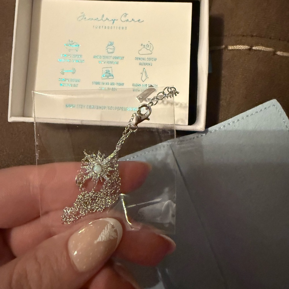 Silver Necklace with Blue Gemstone by [Brand]